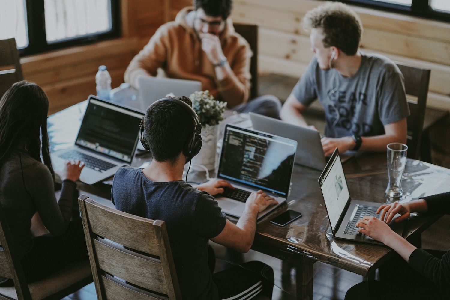 A product and content team collaborating with laptops around a table